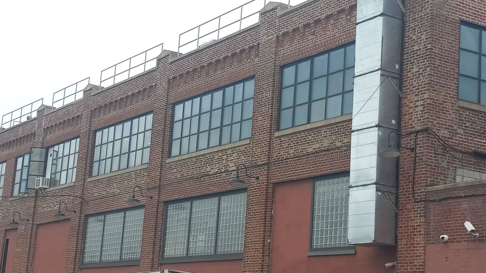 Brick industrial building with rows of large steel-framed windows